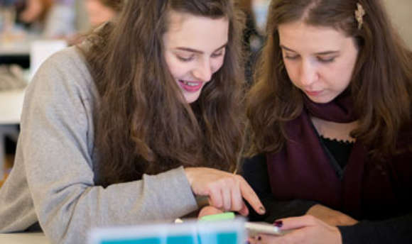 A pair of Ӱֱstudents working together using a mobile app