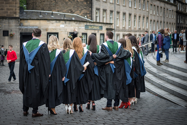 A row of Ӱֱgraduands standing in a row wearing their gowns outside Usher Hall