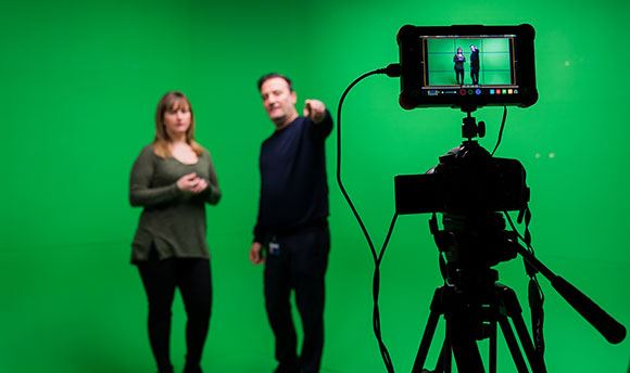 A Ӱֱ student being briefed in front of a green screen