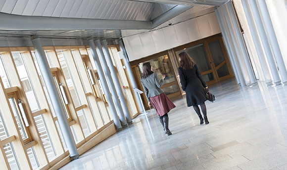 Two women walking down a corridor in Ӱֱ hallway