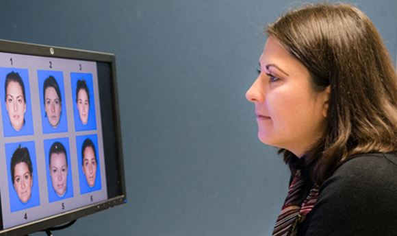 Ӱֱ Psychology Student looking at a computer screen displaying 6 different faces numbered 1-6