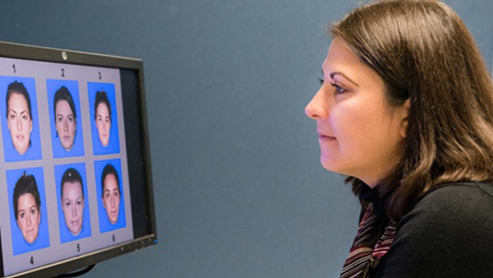 Ӱֱ Psychology Student looking at a computer screen displaying 6 different faces numbered 1-6