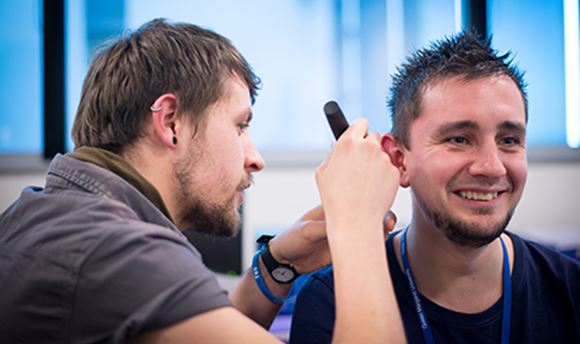 ӰֱHearing Aid Audiology student using a piece of equipment to test another student's hearing